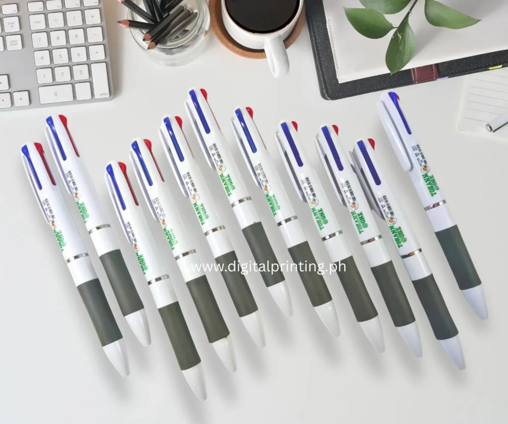 personalized 3-ink pens on top of a table beside a coffee cup and keyboard