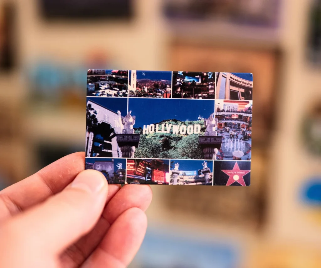 personalized ref magnets featuring a collage of different places, held by a man with a blurred background