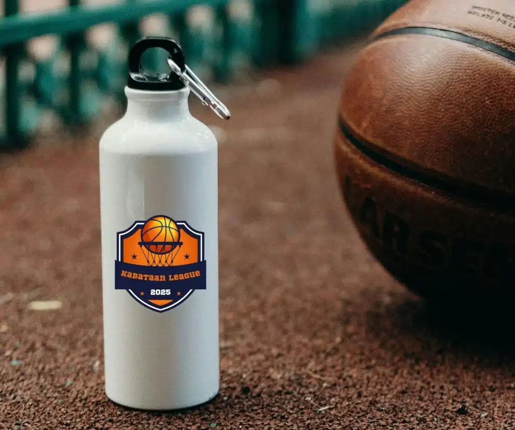 white personalized tumbler with logo placed on the ground beside a basketball