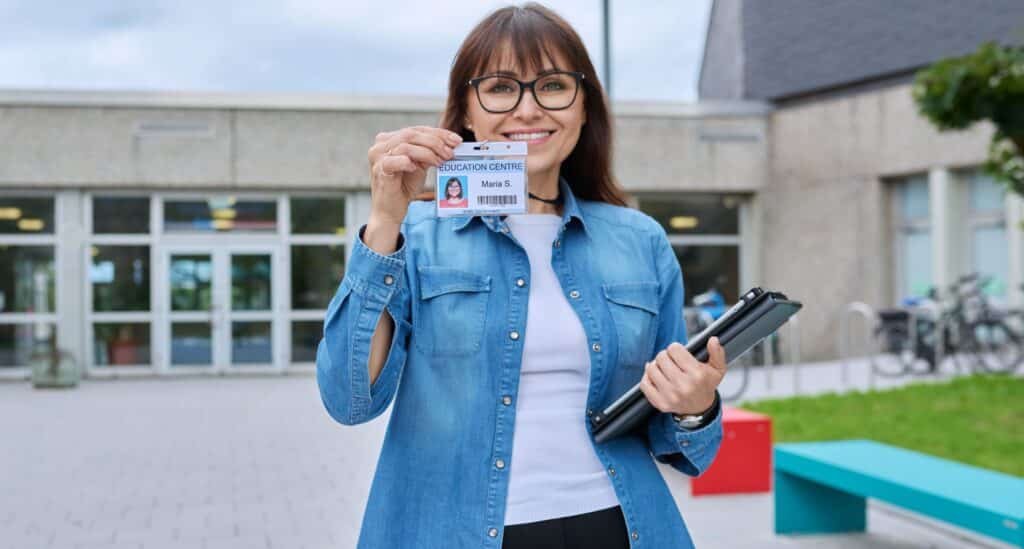 Printing Service – Woman Holding ID Card Outside School Building. Company ID Card | DigitalPrinting.Ph