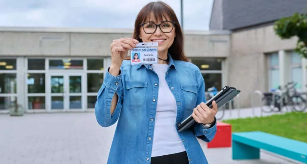 Printing Service – Woman Holding ID Card Outside School Building. Company ID Card | DigitalPrinting.Ph